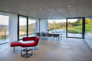 V hlavním obytném prostoru železobetnonovou konstrukci doplňují ocelové sloupky. Nosná konstrukce je přiznaná a spoluvytváří interiér.