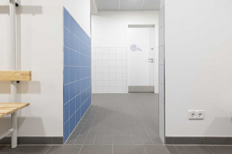 Centrální šatny a sprchy v nové tělocvičně. Dlaždice na podlahách jsou ze série Taurus ve formátu 30 x 30 cm a jsou doplněny mozaikami ve formátu 10 x 10 cm