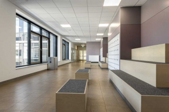 Školní chodby vyžadují odolné podlahy. Zde byla položena dlažba RAKO ze série Extra ve formátu 30 x 30 cm v hnědošedé barvě. Spojovací chodby mezi křídly nabízejí kvalitní vestavěný nábytek s přírodními povrchy