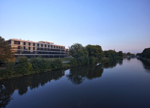 Objekt uzavírá od města plynoucí proměnlivý prostor nábřeží. Svým tvarem vytváří nástupní prostor směrem k nové lávce přes Labe i směrem k nábřeží. Parter mezi budovou a řekou byl navržen jako kombinace pobytových trávníků a kvetoucích luk.