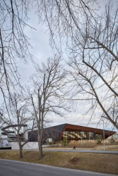 Objekt reaguje na svažitý pozemek, jeho střecha kopíruje úhel přilehlé komunikace. Na jižní stranu se zvyšuje a otevírá