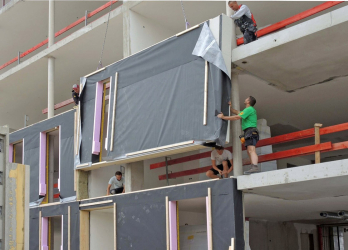 Obr. č. 2 – Montáž prefabrikovaných dřevěných fasádních dílců na železobetonovou konstrukci