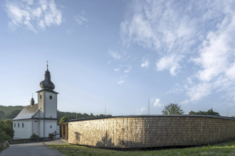 Novostavba byla navržena pro malou obec v údolí potoka tak, aby vytvořila veřejný prostor a zároveň nekonkurovala kostelu. Na fasádě sálu je na dřevěném roštu štípaný šindel z českého modřínu. Pod šindely je provětrávaná mezera a hydroizolace.