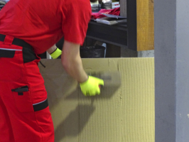 Obr. č. 1: Nanášení lepidla na rubovou stranu obkladového prvku