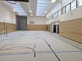 Některá nároží a tělocvična jsou kontrastně obloženy cembonitovými deskami a fotovoltaickými panely