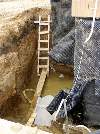 Obr. 5a: Příčinou prosakování nadržené srážkové vody do interiéru byly mimo jiné defekty izolace a drenážního systému. Např. neprůchodné potrubí, svislá izolace poškozená protlačením nopů a chybné detaily napojení izolací.